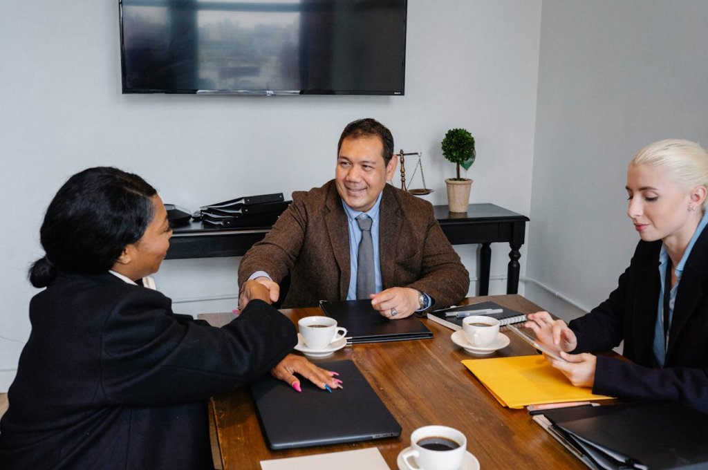 A diverse group of small business owners smiling and discussing strategies around a table, representing collaboration and growth.